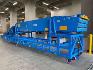 プラットホームがない倉庫に架台一体型伸縮コンベヤを導入。高低差のあるデバンニング作業を効率化